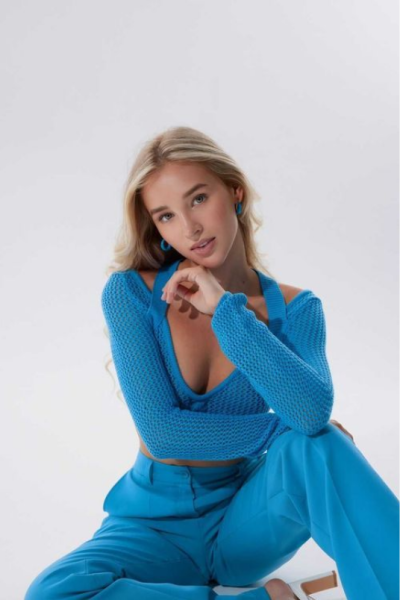A woman in blue dress posing for the camera.